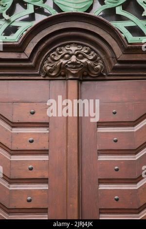 Détails de porte d'entrée en bois avec visage sculpté d'une créature mythique imaginaire sur un bâtiment, Prague, République tchèque. Banque D'Images