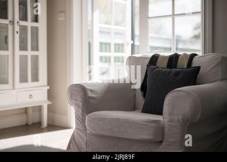 Un gros plan d'un fauteuil léger dans un appartement moderne contre la porte du patio Banque D'Images