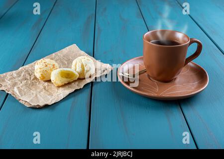 Pains au fromage brésilien à côté d'une tasse de café et d'une cuillère dorée. Banque D'Images