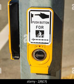 Bouton-poussoir pour l'affiche de passage de côté. Bouton de tableau de concordance et panneau sur le poteau de rue. Contrôle de la circulation. Traversez une route en toute sécurité. Personne, mise au point sélective, photo de rue Banque D'Images