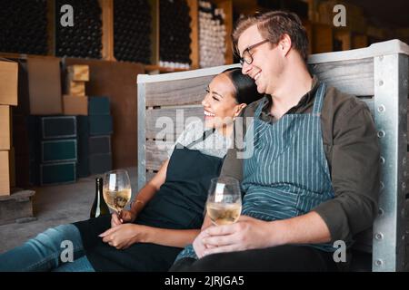 Rires entre amis, dégustation de vin et couple avec sourire heureux en se liant à la ferme de campagne avec un verre de boisson. Homme, femme ou travailleur interracial Banque D'Images