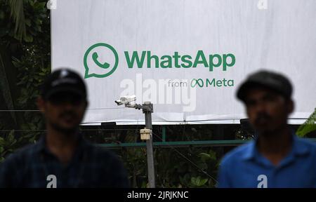 Mumbai, Inde. 24th août 2022. Les hommes marchent devant le logo WhatsApp affiché sur une palissade à Mumbai. WhatsApp est un protocole de messagerie instantanée et de voix sur Internet appartenant à la société américaine Meta qui permet aux gens de se connecter entre eux pour des réseaux occasionnels ou liés à l'entreprise dans le monde entier. Crédit : SOPA Images Limited/Alamy Live News Banque D'Images