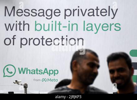 Mumbai, Inde. 24th août 2022. Les hommes marchent devant le logo WhatsApp affiché sur une palissade à Mumbai. WhatsApp est un protocole de messagerie instantanée et de voix sur Internet appartenant à la société américaine Meta qui permet aux gens de se connecter entre eux pour des réseaux occasionnels ou liés à l'entreprise dans le monde entier. Crédit : SOPA Images Limited/Alamy Live News Banque D'Images