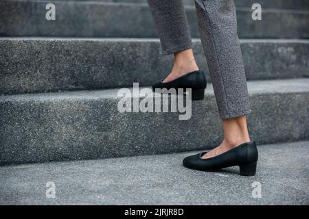 Monter les escaliers en ville, les jambes de femme d'affaires en gros plan se précipitent sur l'escalier, heure de pointe pour travailler dans le bureau, pressé le matin, à pied Banque D'Images