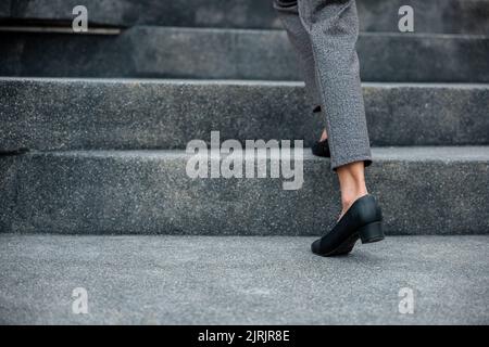 Monter les escaliers en ville, les jambes de femme d'affaires en gros plan se précipitent sur l'escalier, heure de pointe pour travailler dans le bureau, pressé le matin, à pied Banque D'Images