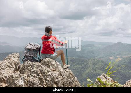 Randonneur femme profiter de la vue au coucher du soleil pic de montagne falaise Banque D'Images