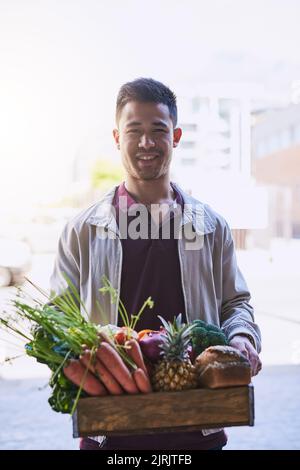 Vous n'aurez plus jamais besoin d'aller au magasin vous-même. Portrait d'un coursier effectuant une livraison d'épicerie. Banque D'Images