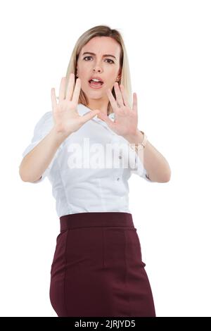 Reculez. Photo en studio d'une jeune femme d'affaires faisant un geste d'arrêt sur fond blanc. Banque D'Images