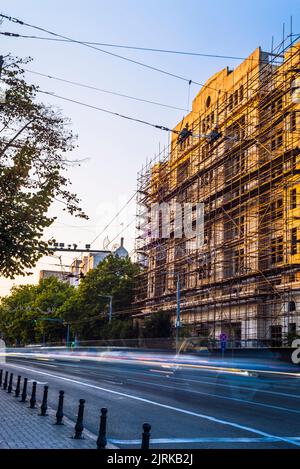 Échafaudage du site immeuble d'appartements en construction par un beau jour immeuble résidentiel en bois de plusieurs étages exposé à la rue. Voiture Banque D'Images