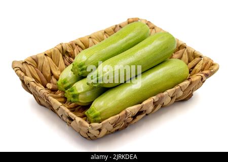 Courgettes bio. Courgettes fraîches dans un panier isolé sur fond blanc. Légumes, nourriture végétalienne saine. Gros plan Banque D'Images