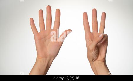 Geste des mains des femmes comptant sur les doigts huit côté de la paume Banque D'Images