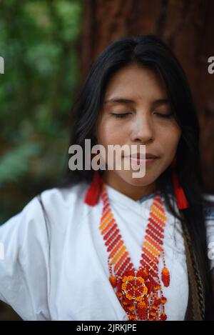 Portrait en gros plan de la jeune femme indigène Arhuaco avec les yeux fermés dans une forêt de Colombie Banque D'Images