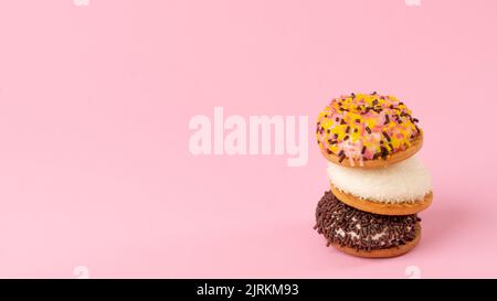 Gâteaux avec décoration pour la confiserie - fond rose avec bonbons, espace pour le texte. Photo de haute qualité Banque D'Images