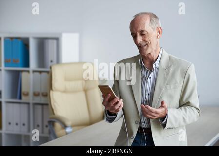 Portrait d'un homme d'affaires âgé qui a remporté un franc succès en vidéo avec un collègue Banque D'Images
