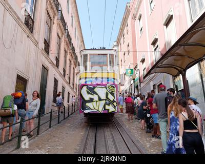 Tram aka tramway aka tramway à Lisbonne. Les gens se rassemblent à l'arrêt et les touristes avec les sacs à dos marchent au-delà. Portugal Banque D'Images