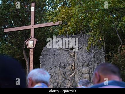 La douzième station du chemin de la Croix (« Jésus meurt sur la Croix ») et certains croyants catholiques priant alors qu'ils grimpent sur le Mont Križevac (Medjugorje) Banque D'Images