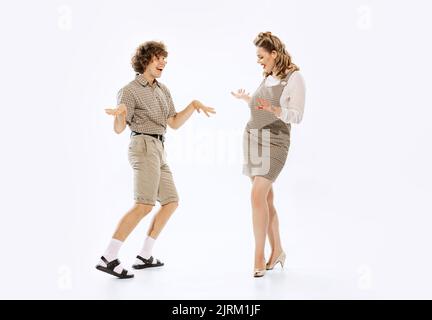 Couple expressif de danseurs de style rétro vintage dansant la danse sociale isolée sur fond blanc. Traditions intemporelles, 60s ,70s américain Banque D'Images