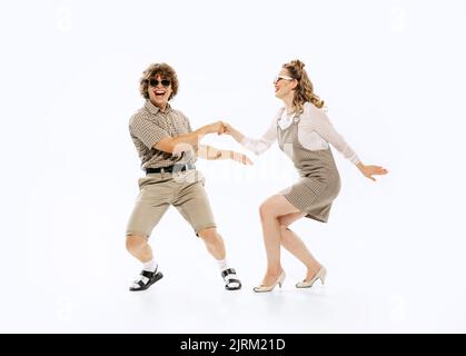 Couple expressif de danseurs de style rétro vintage dansant la danse sociale isolée sur fond blanc. Traditions intemporelles, 60s ,70s américain Banque D'Images