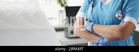 Femme médecin avec bras croisés debout dans la salle d'hôpital de près Banque D'Images