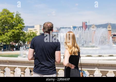 Barcelone, Espagne - 6 mai 2022: Couple avec leur dos à la fontaine magique de Montjuic, Barcelone (Espagne). Banque D'Images