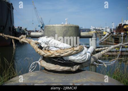 Un seul dispositif d'amarrage avec des cordes enroulées maintient le navire sur le quai. Gros plan Banque D'Images