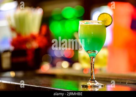 Cocktail sur le comptoir du bar avec lumières colorées en arrière-plan. Banque D'Images