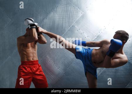 Deux boxeurs hommes combattant la boxe muay thai. Banque D'Images