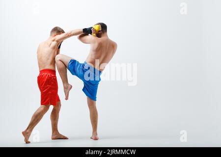 Deux boxeurs hommes combattant muay thai boxe fond blanc. Banque D'Images