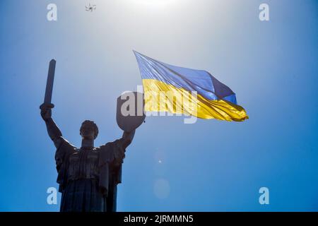 KIEV, UKRAINE - le 24 AOÛT 2022 - le drapeau de l'Ukraine (260 m2) flotte devant le Monument de la mère patrie comme un groupe de drones porte les signes Banque D'Images