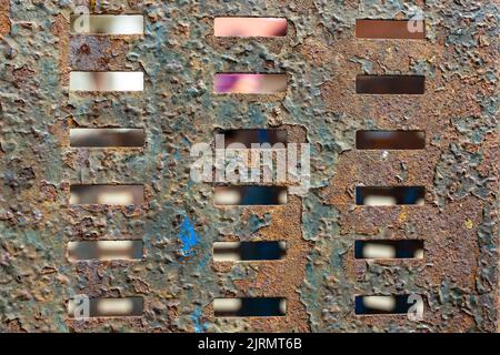 Feuille de métal rouillée avec répétition de trous rectangulaires. Grille pour les ressources graphiques, gros plan Banque D'Images