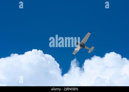 Un petit avion volant contre le ciel bleu et les nuages blancs ensoleillées au Mexique Banque D'Images