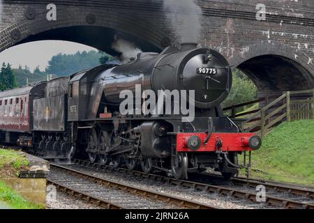 grand train à vapeur noir passant sous un pont Banque D'Images