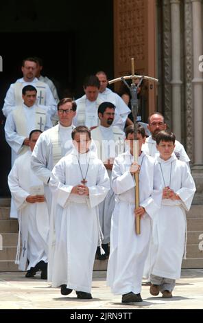 Une procession religieuse sort de l'église catholique romaine de Saint-Patrick après un service commémoratif pour le designer de mode tué Gianni Versace, 18 juillet 1997 à Miami, en Floride. Versace a été abattu par Andrew Cunanan sur les marches à l'extérieur de son manoir de 15 juillet. Banque D'Images