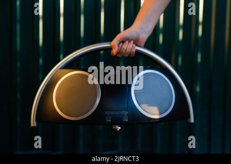 Flou artistique main tenant l'enregistreur de musique rétro. Ampli-tuner radio stéréo portable de type boombox rétro avec lecteur/enregistreur de cassettes. PH filtré ancien style vintage Banque D'Images