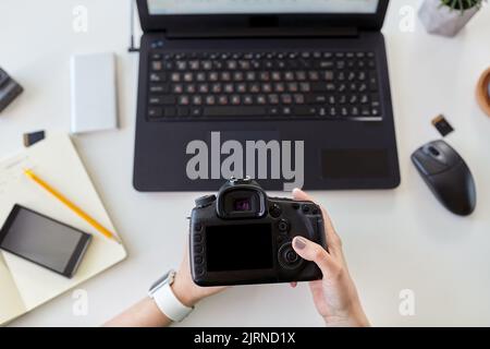 femme avec appareil photo et ordinateur portable au bureau Banque D'Images