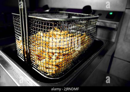 Un panier de frites fraîchement préparées prêt à être servi dans un restaurant Banque D'Images