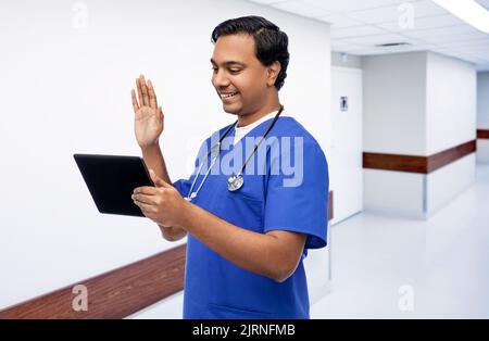 un médecin ou une infirmière de sexe masculin a un appel vidéo sur un pc tablette Banque D'Images