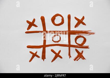 le jeu de tic-tac-toe est tiré sur des peintures sur papier blanc, jouer et se reposer, le jeu des enfants de noughts et de croix Banque D'Images