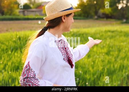 Recentrer le portrait de la jeune femme ukrainienne. Arrière-plan nature prairie. Montrer signe amour Ukraine. Fille ukrainienne souriante montrant l'amour gestuel. Vyshyvanka. Banque D'Images