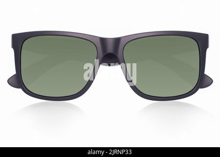 Lunettes de soleil noires mates à monture en plastique avec verres polarisés verts sur fond blanc et reflets de l'ombre depuis la vue avant Banque D'Images