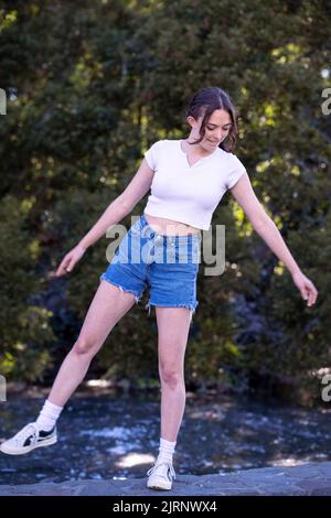 Portrait en longueur de la jeune femme debout au bord d'un lac artificiel Banque D'Images