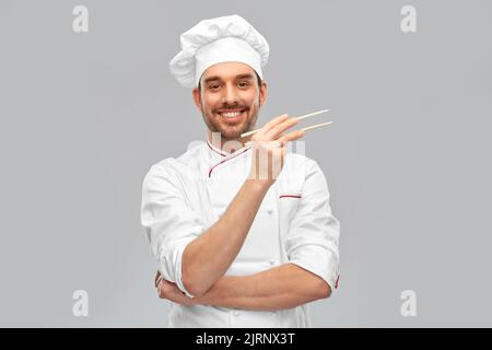 joyeux chef masculin souriant avec des baguettes Banque D'Images