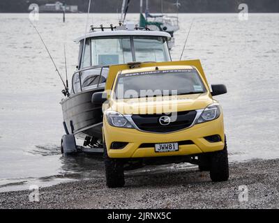 Camion jaune Mazda BT-50 génération II (2011-2015) tirant le bateau-remorque de Ferran hors de l'eau. Banque D'Images