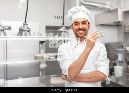 joyeux chef masculin souriant avec des baguettes Banque D'Images