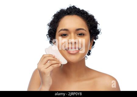 bonne femme massant son visage avec l'outil gua sha Banque D'Images