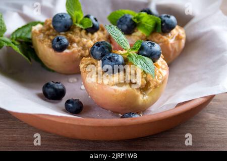 Cuit dans un four aux pommes avec du fromage cottage, de la cannelle et de la menthe sur papier parchemin. Alimentation. Plat d'automne. Traditions de la cuisine ukrainienne et allemande. Banque D'Images