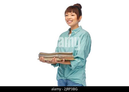 jeune femme asiatique souriante triant des déchets de papier Banque D'Images