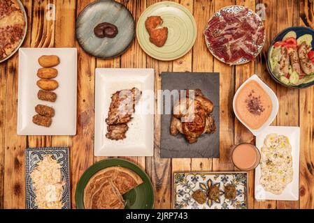 Ensemble de plats de restauration rapide et tapas typiquement espagnoles, pommes de terre alioli, plateau de jambon nourri au gland, croquettes assorties, empanada galicien, salmorejo avec crouton Banque D'Images