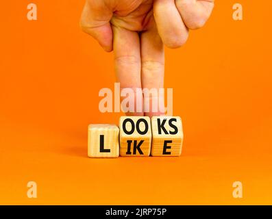 Ressemble à un symbole. Les mots concept ressemblent à des cubes en bois. Main d'homme d'affaires. Belle table orange fond orange. Affaires, citations populaires et Banque D'Images