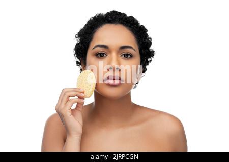 Jeune femme en train de nettoyer le visage avec une éponge exfoliante Banque D'Images